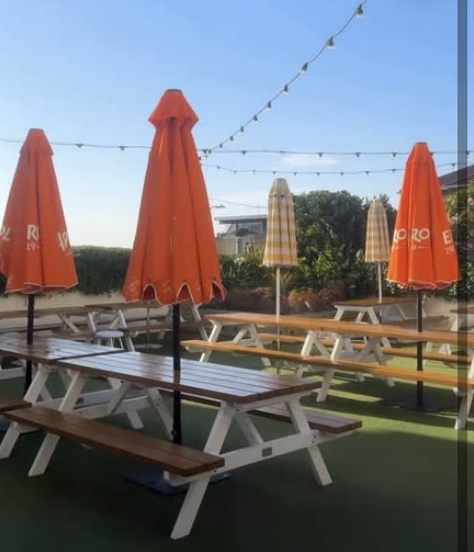 Outdoor beer garden with timber tables and festoon lights