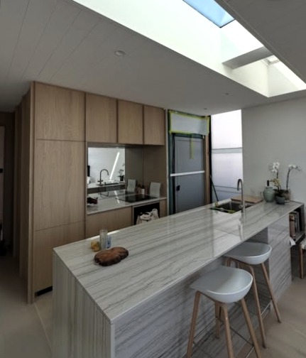 Kitchen with timber joinery, stone island benchtop and skylight